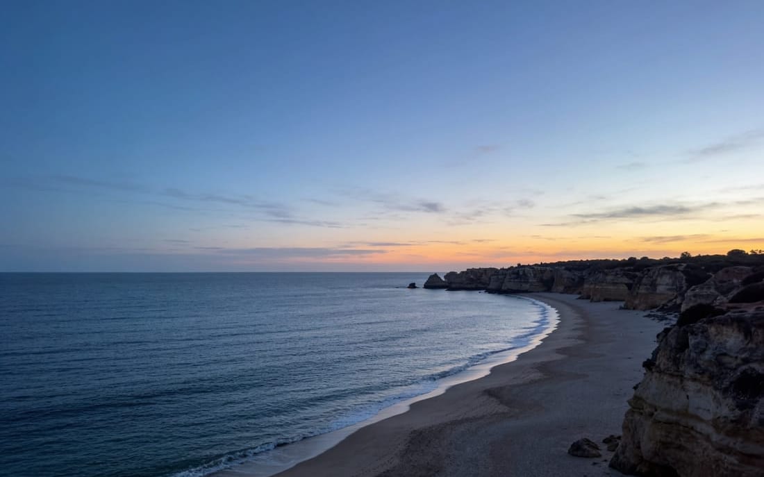 A wide empty stretch of Algarve coastline at dusk